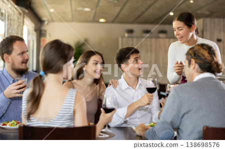 Waitress takes order from group of friends Waitress takes order from group of friends 138698576