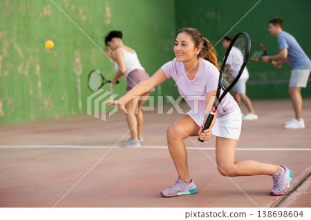 Woman playing frontenis on outdoor pelota court Woman playing frontenis on outdoor pelota court 138698604