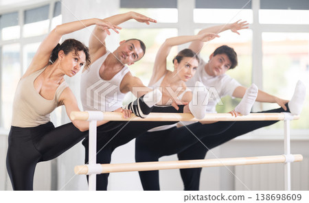 Group of dancers doing stretching at barre 138698609