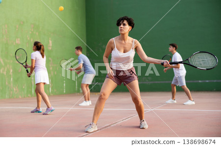 Woman pelota player hitting ball with racket Woman pelota player hitting ball with racket 138698674