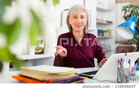 Positive mature woman working at office Positive mature woman working at office 138698697