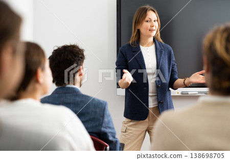 Experienced female teacher giving lecture to group of student Experienced female teacher giving lecture to group of student 138698705