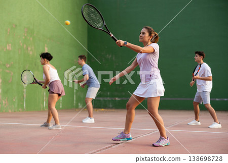 Woman playing frontenis with partners at sunny day, healthy lifestyle concept 138698728