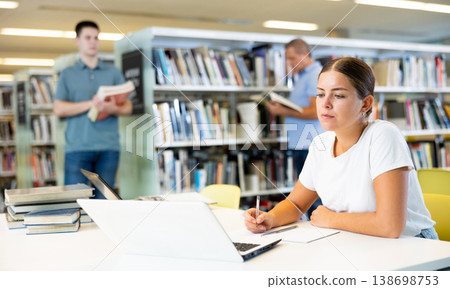 Caucasian school student girl doing research on project laptop 138698753