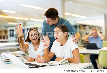 Loud young students laughing together with a laptop 138698761