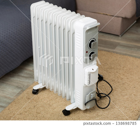 Electric oil heater on floor in room Electric oil heater on floor in room 138698785