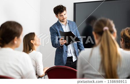 Young male tutor teaching students in college classroom 138698911