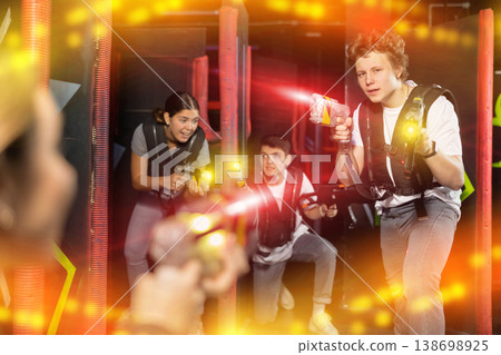 Three people having fun playing lasertag in arena Three people having fun playing lasertag in arena 138698925