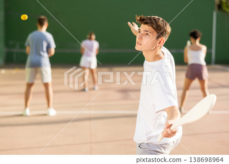 Young male pelota player hitting ball with wooden racket Young male pelota player hitting ball with wooden racket 138698964