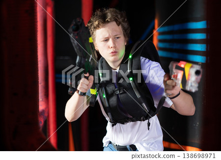 Portrait of man with laser gun having fun with family on laser tag arena Portrait of man with laser gun having fun with family on laser tag arena 138698971