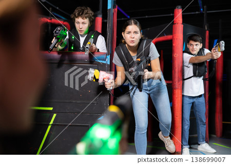 Three people playing lasertag in arena Three people playing lasertag in arena 138699007
