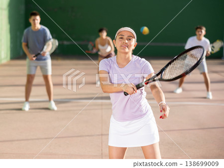 Expressive resolved fit girl playing frontenis ball friendly match on court Expressive resolved fit girl playing frontenis ball friendly match on court 138699009