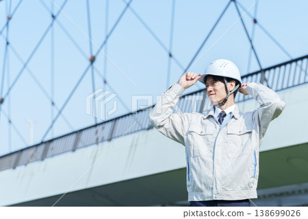 A portrait of a civil engineer looking up at the sky. A portrait of a civil engineer looking up at the sky. 138699026