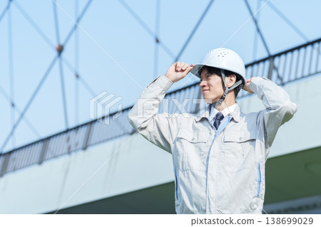 A portrait of a civil engineer looking up at the sky. A portrait of a civil engineer looking up at the sky. 138699029