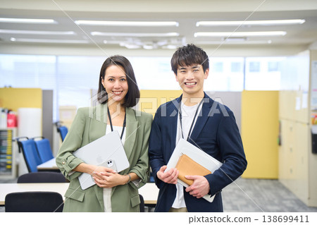 兩名日本男女系統工程師在外資IT公司的辦公室聊天微笑。 138699411