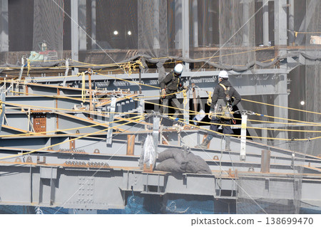 Workers performing work at heights at a steel frame construction site and safety net 3 Workers performing work at heights at a steel frame construction site and safety net 3 138699470