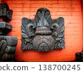 Dark stone carving adorns bright red brick wall 138700245