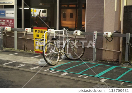 A silver sports bicycle parked in a paid bicycle parking area in the city. 138700481