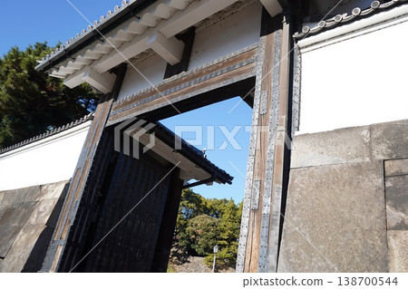 The imposing, historic castle gate and magnificent stone walls stand out against the blue sky. The imposing, historic castle gate and magnificent stone walls stand out against the blue sky. 138700544