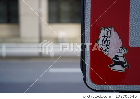 一張貼紙從路標背面脫落了一半。 一張貼紙從路標背面脫落了一半。 138700549