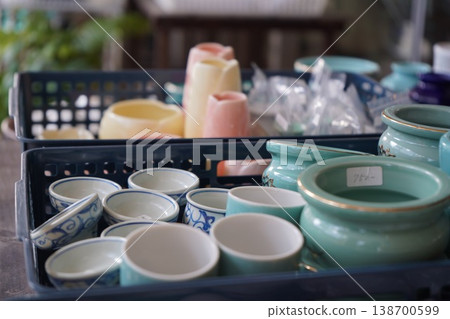 跳蚤市場裡，一些小陶瓷片和茶杯隨意地擺放在藍色籃子裡。 138700599
