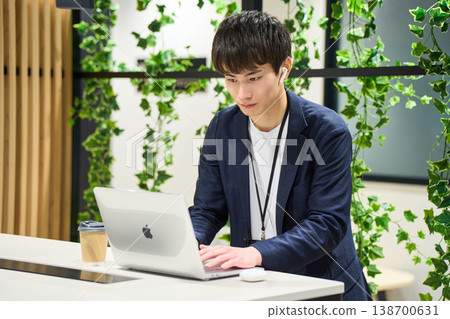 一位來自外資公司的年輕男性系統工程師在綠樹環繞的辦公室裡,站在辦公桌前專心處理電腦工作。 一位來自外資公司的年輕男性系統工程師在綠樹環繞的辦公室裡,站在辦公桌前專心處理電腦工作。 138700631