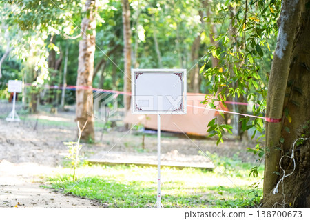 An ornamental frame on a slim stand sits under warm light. The empty center leaves room for formal outdoor notice text. 138700673