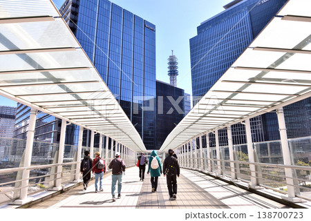 People walking on the Yokohama Minato Mirai pedestrian bridge under a blue sky. People walking on the Yokohama Minato Mirai pedestrian bridge under a blue sky. 138700723