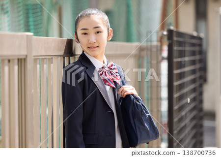 A female high school student wearing a school uniform. 138700736