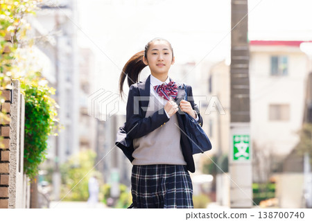 A student, a high school girl running in her uniform. 138700740