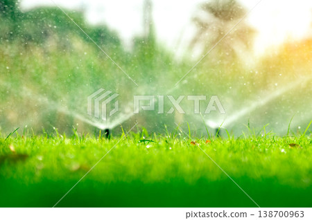 Automatic lawn sprinkler watering green grass. Sprinkler with automatic system. Garden irrigation system watering lawn. Water saving or water conservation from sprinkler system with adjustable head. 138700963