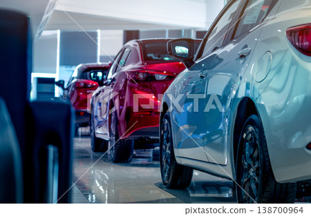Rear view of new luxury red and white car parked in modern show room. Selective focus on white shiny car. Car dealership concept. Showroom interior. Automotive industry on coronavirus crisis concept. 138700964