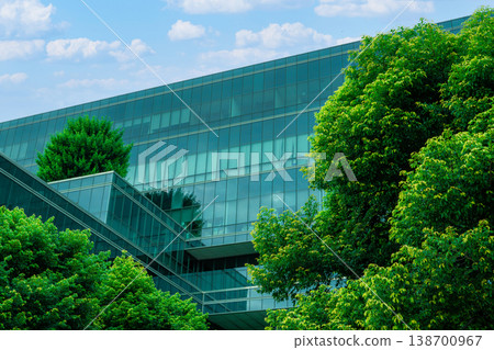 Eco-friendly building in the modern city. Sustainable glass office building with trees for reducing heat and carbon dioxide. Office building with green environment. Corporate building reduce CO2. 138700967