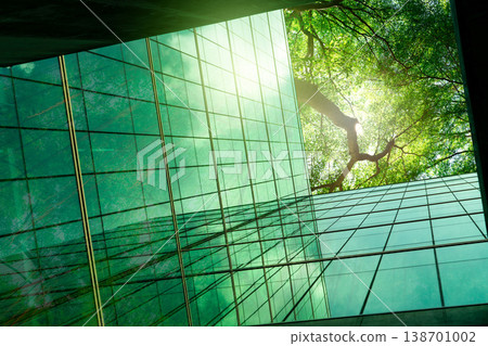 Sustainble green building. Eco-friendly building in modern city. ESG. Sustainable glass office building with green tree. Office with green environment. Corporate sustainability. Net zero emission. Sustainble green building. Eco-friendly building in modern city. ESG. Sustainable glass office building with green tree. Office with green environment. Corporate sustainability. Net zero emission. 138701002
