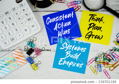 Consistent Action Wins, Think Plan Grow, Systems Build Empires text written on paper note with calculator and magnifying glass on wooden background 138701189