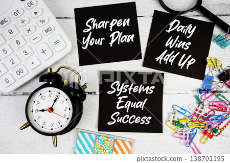 Sharpen Your Plan, Daily Wins Add Up, Systems Equal Success text written on paper note with calculator and magnifying glass on wooden background 138701195