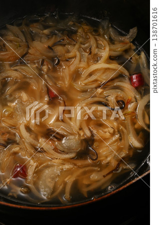 A scene of cooking onions in a frying pan. 138701616