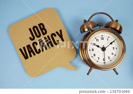 Job Vacancy text with alarm clock on blue background Job Vacancy text with alarm clock on blue background 138701660