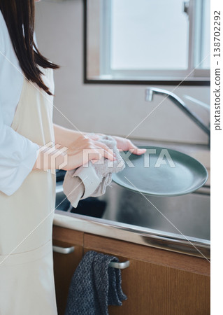一位女性在廚房洗碗;家務勞動和日常生活的畫面;一種乾淨整潔、注重健康的生活方式。 一位女性在廚房洗碗;家務勞動和日常生活的畫面;一種乾淨整潔、注重健康的生活方式。 138702292