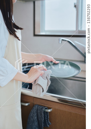 一位女性在廚房洗碗;家務勞動和日常生活的畫面;一種乾淨整潔、注重健康的生活方式。 一位女性在廚房洗碗;家務勞動和日常生活的畫面;一種乾淨整潔、注重健康的生活方式。 138702293