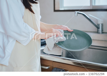 一位女性在廚房洗碗;家務勞動和日常生活的畫面;一種乾淨整潔、注重健康的生活方式。 一位女性在廚房洗碗;家務勞動和日常生活的畫面;一種乾淨整潔、注重健康的生活方式。 138702294