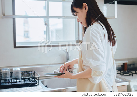 一位婦女在廚房洗碗：描繪日常家務和注重生活品質的場景。 138702323
