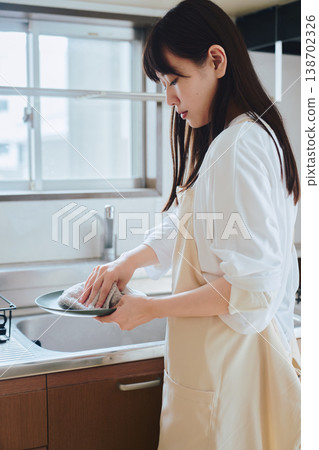一位婦女在廚房洗碗：描繪日常家務和注重生活品質的場景。 138702326