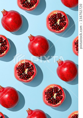 Red pomegranates spread out on a light blue surface Red pomegranates spread out on a light blue surface 138702720