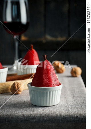Pears are placed in white dishes on a table with wine and nuts Pears are placed in white dishes on a table with wine and nuts 138702734