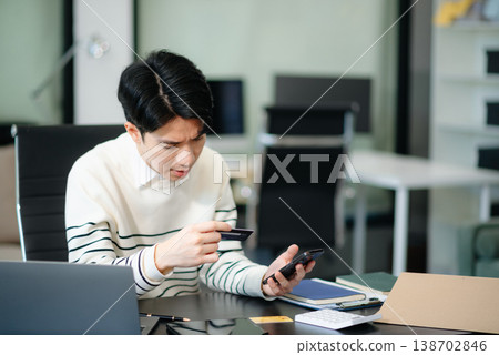 Financial owe, hand of asian man sitting, holding credit card, stressed by calculate expense from invoice or bill, no money Financial owe, hand of asian man sitting, holding credit card, stressed by calculate expense from invoice or bill, no money 138702846