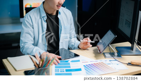Asian male programmer working with tablet, laptop, and desktop in tech office. Coding, software development Asian male programmer working with tablet, laptop, and desktop in tech office. Coding, software development 138702884