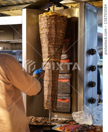 Beef kebab being shaved off on a rotating grill (a scene of doner kebab being prepared) Beef kebab being shaved off on a rotating grill (a scene of doner kebab being prepared) 138703084