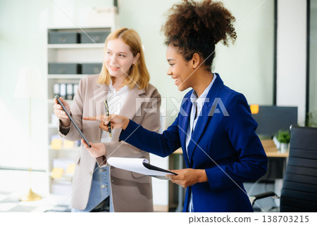 Businesswoman leading team meeting and using tablet and laptop computer with financial Businesswoman leading team meeting and using tablet and laptop computer with financial 138703215
