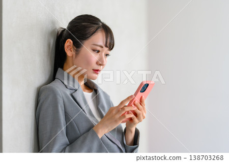 一位女商人正在操作智慧型手機的側面視角。 138703268